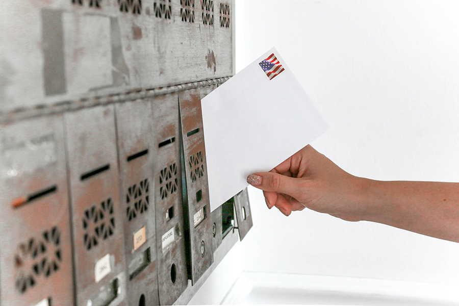 Envelope going into mailbox to represent the pre-collection letter services provided by Commercial Collectors Inc