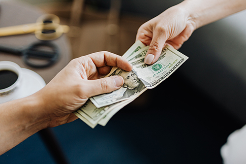 Person handing over cash to represent commercial collections agency in Blaine, MN